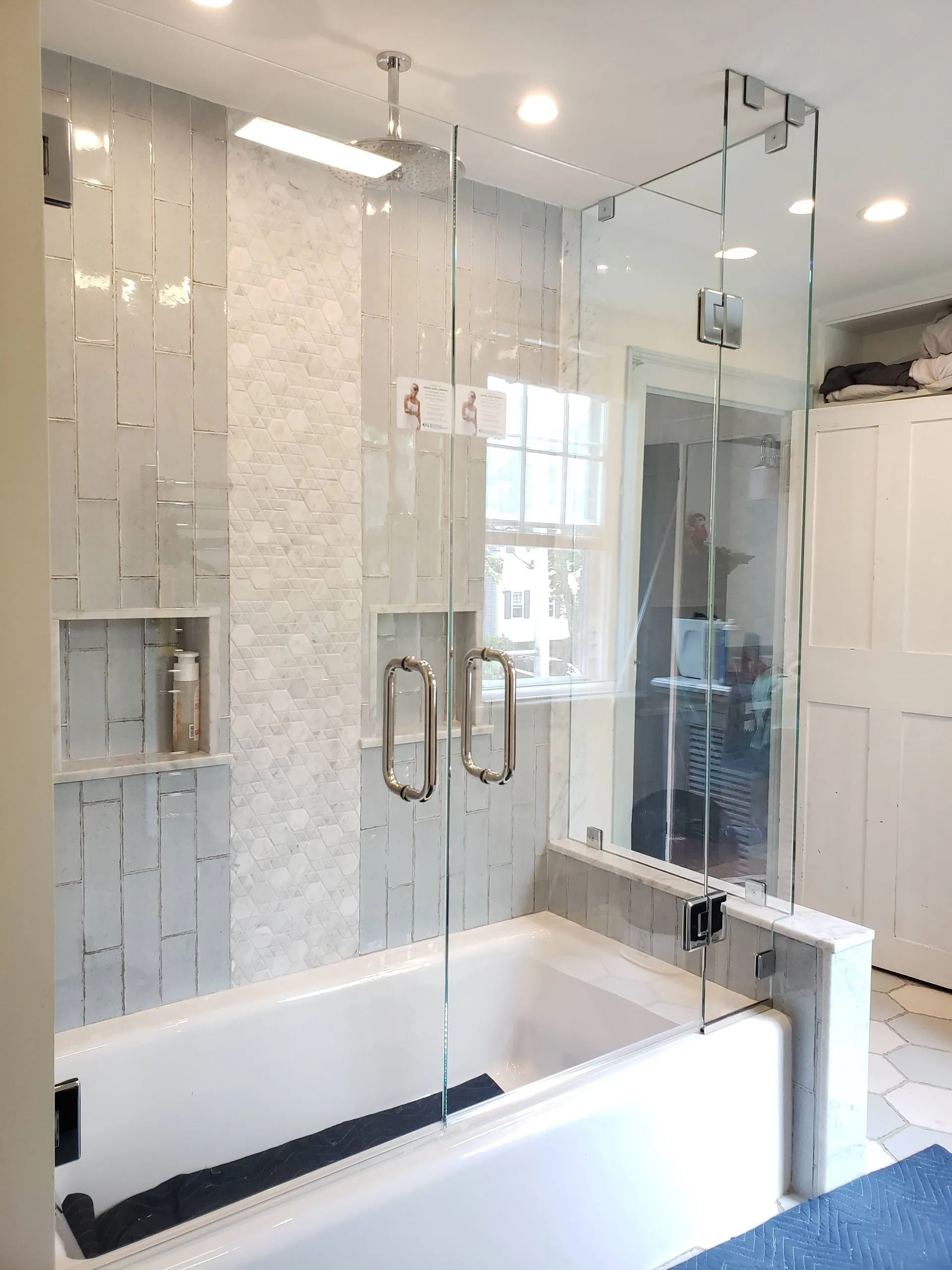 Tub enclosure with hinged glass door